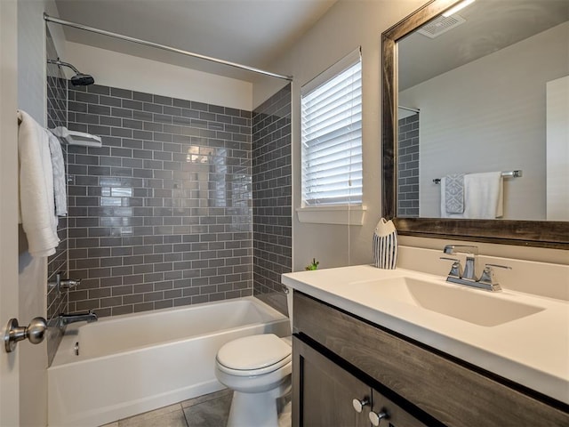 full bathroom featuring vanity, tiled shower / bath combo, tile patterned floors, and toilet