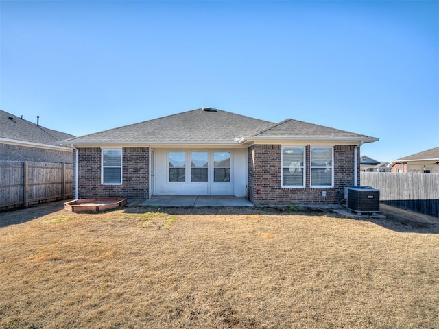 rear view of house featuring a yard, a patio, and central air condition unit