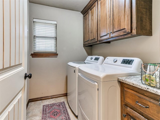 clothes washing area featuring washing machine and dryer and cabinets