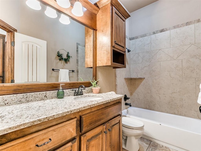 full bathroom featuring tiled shower / bath, vanity, and toilet