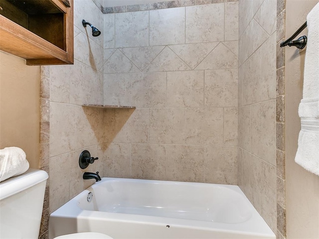 bathroom with tiled shower / bath combo and toilet