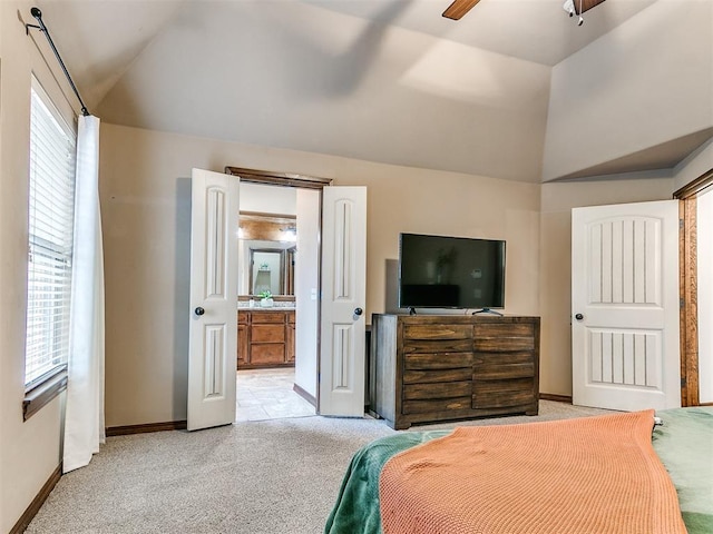 carpeted bedroom featuring multiple windows, ensuite bath, vaulted ceiling, and ceiling fan