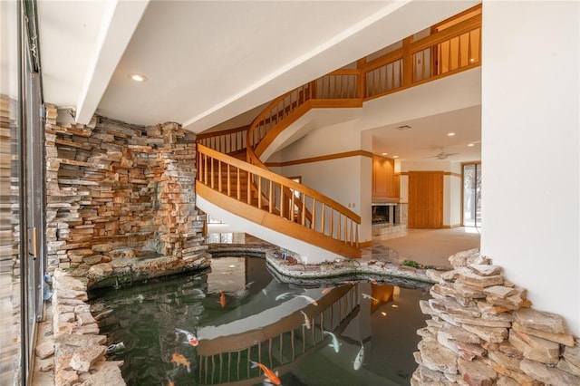 unfurnished living room with recessed lighting, beam ceiling, and a high ceiling