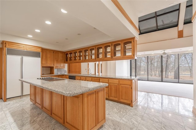 kitchen with glass insert cabinets, a center island, a peninsula, and black appliances