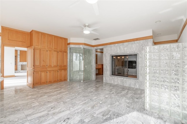 unfurnished living room with visible vents, a ceiling fan, and a glass covered fireplace