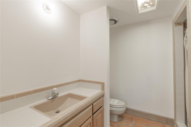 bathroom with tile patterned flooring, vanity, walk in shower, and toilet