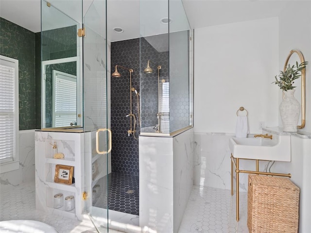 bathroom with an enclosed shower, sink, and tile walls