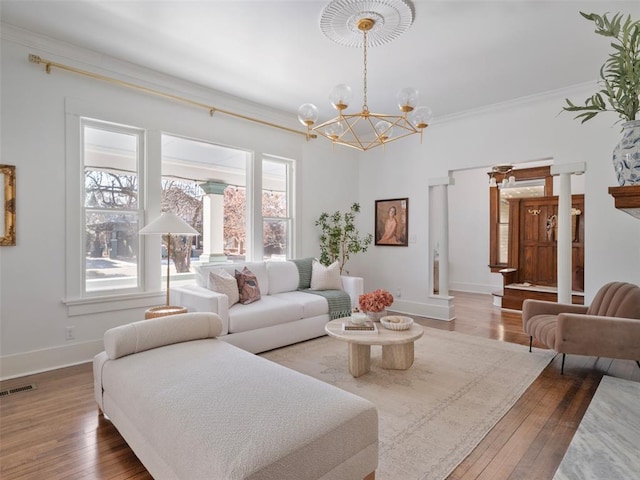 living room with crown molding, dark hardwood / wood-style floors, and a chandelier