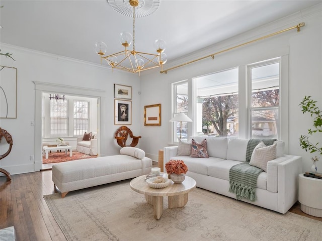 living room featuring hardwood / wood-style flooring, crown molding, and an inviting chandelier