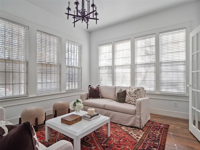 living room featuring dark hardwood / wood-style flooring, a healthy amount of sunlight, and an inviting chandelier