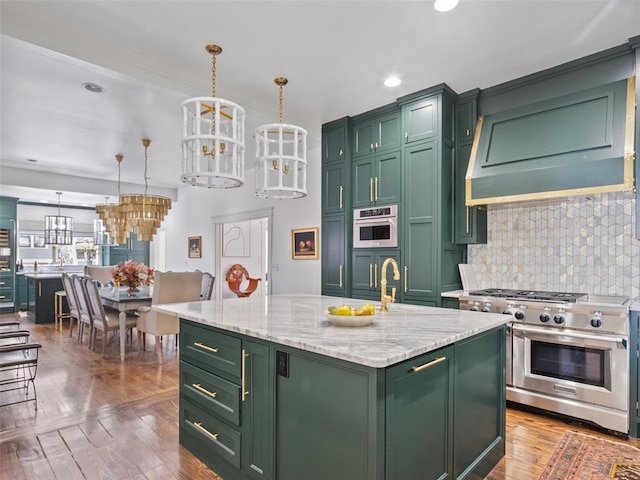 kitchen with green cabinetry, decorative light fixtures, a center island with sink, light stone countertops, and high end stove