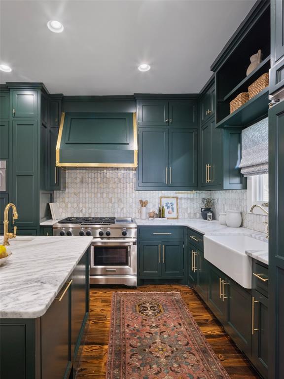 kitchen with premium range hood, dark wood-type flooring, sink, light stone counters, and stainless steel range