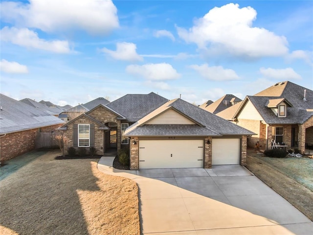 view of front facade featuring an attached garage, brick siding, a shingled roof, fence, and concrete driveway