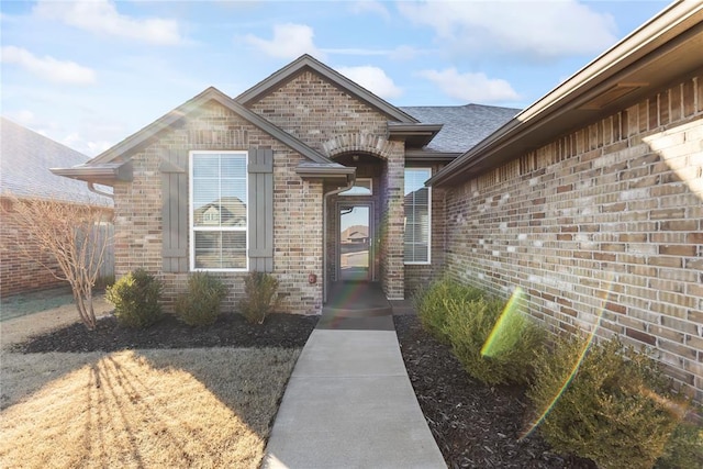 entrance to property featuring brick siding