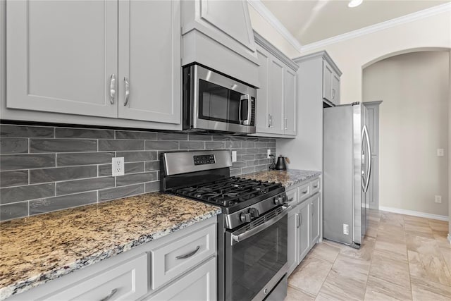 kitchen with ornamental molding, stainless steel appliances, decorative backsplash, and stone counters