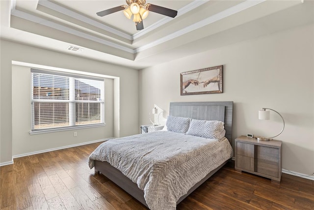 bedroom featuring crown molding, ceiling fan, a tray ceiling, and dark hardwood / wood-style flooring