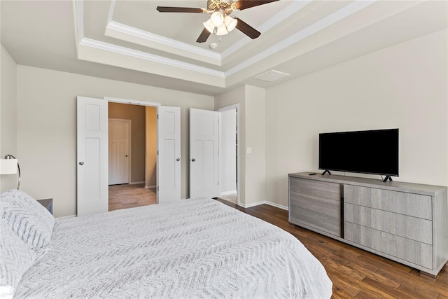 bedroom with a raised ceiling, crown molding, dark hardwood / wood-style floors, and ceiling fan