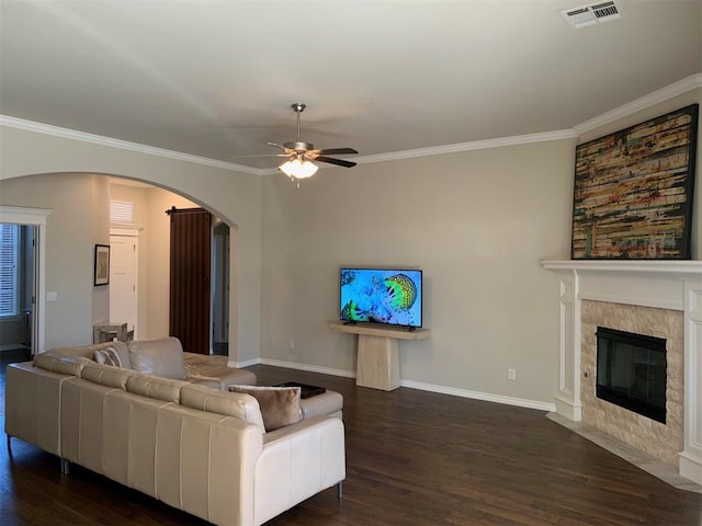 living area with arched walkways, dark wood-type flooring, a fireplace with flush hearth, and visible vents