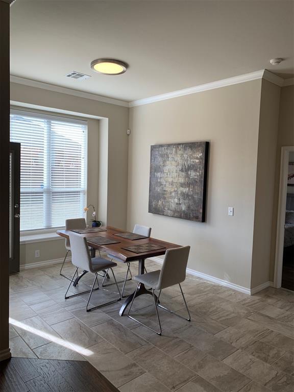 dining room featuring baseboards, visible vents, and ornamental molding