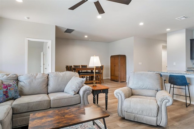 living room with ceiling fan and light wood-type flooring