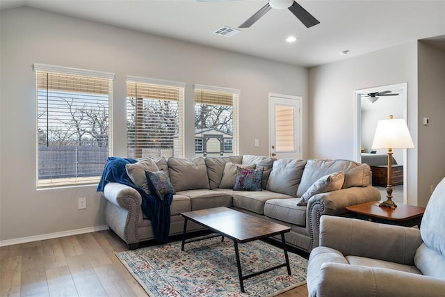 living room with ceiling fan and light hardwood / wood-style flooring