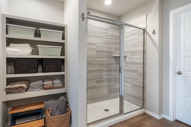 bathroom with an enclosed shower and hardwood / wood-style floors