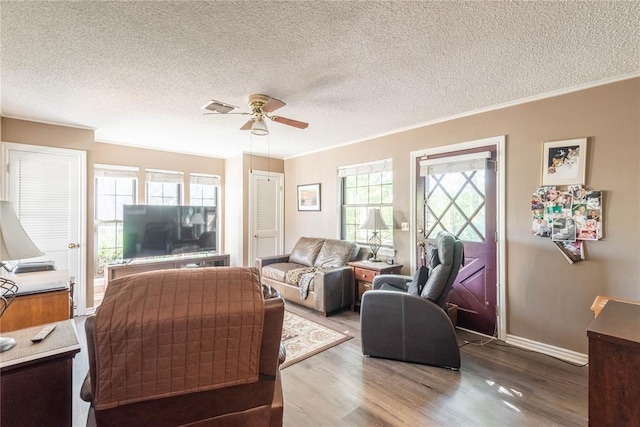 living room featuring ornamental molding, plenty of natural light, hardwood / wood-style floors, and ceiling fan