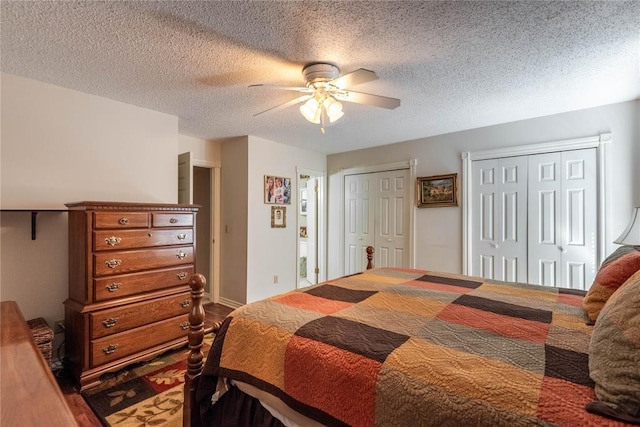 bedroom featuring ceiling fan, a textured ceiling, and two closets