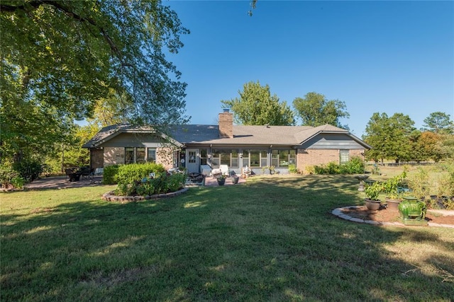 rear view of property featuring a patio and a lawn