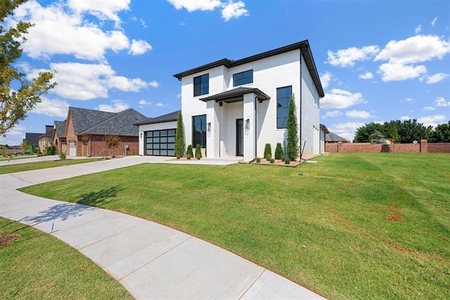 contemporary home with a front yard, concrete driveway, fence, and an attached garage