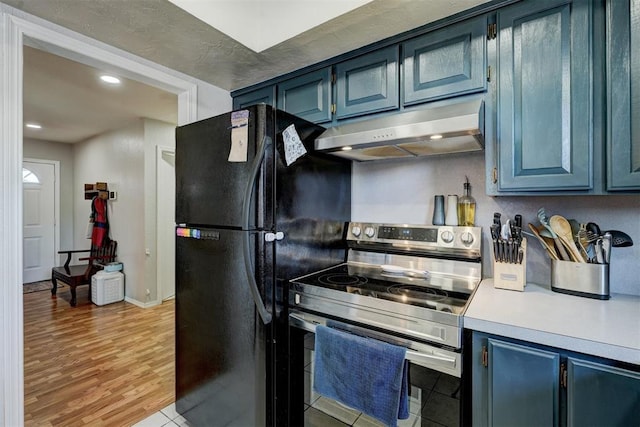 kitchen featuring black fridge, blue cabinetry, and electric stove