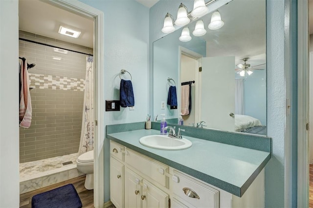 bathroom with toilet, wood-type flooring, vanity, curtained shower, and ceiling fan