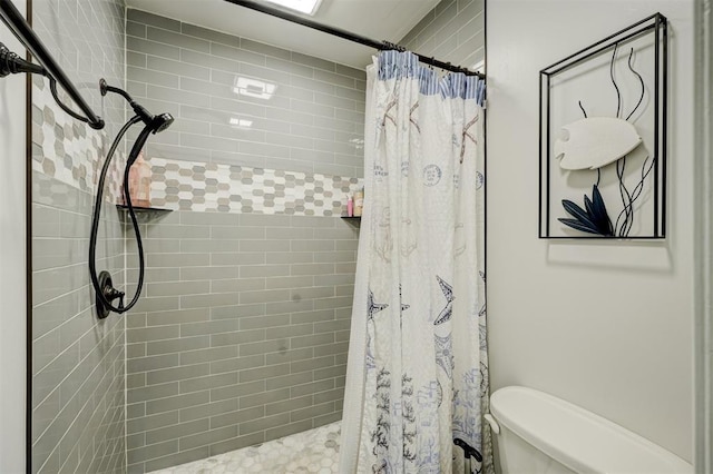 bathroom with a shower with curtain and toilet