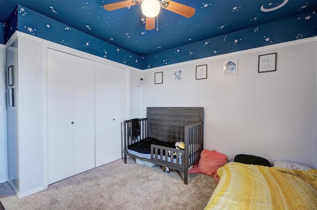 carpeted bedroom with ceiling fan and a closet