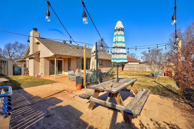 exterior space featuring a patio, a yard, and a storage unit