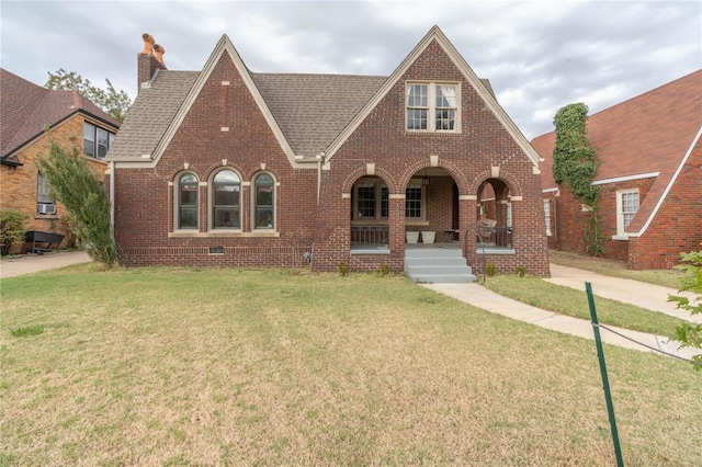 tudor house with a front yard and a porch