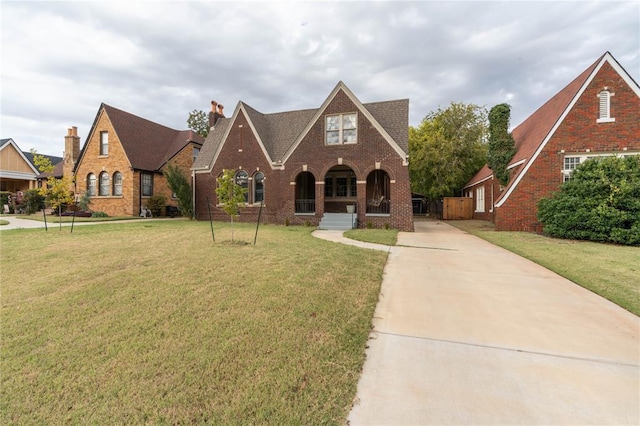 tudor home with a front lawn