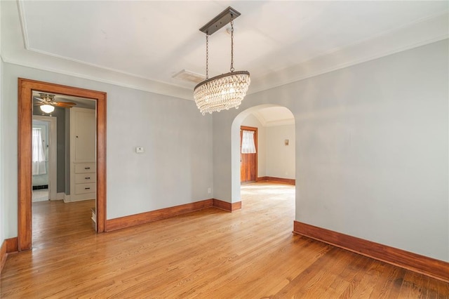 unfurnished room featuring ornamental molding, a notable chandelier, and light wood-type flooring