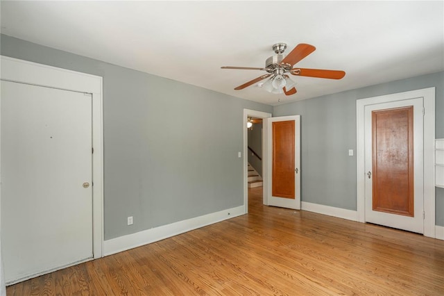 empty room with ceiling fan and light hardwood / wood-style flooring