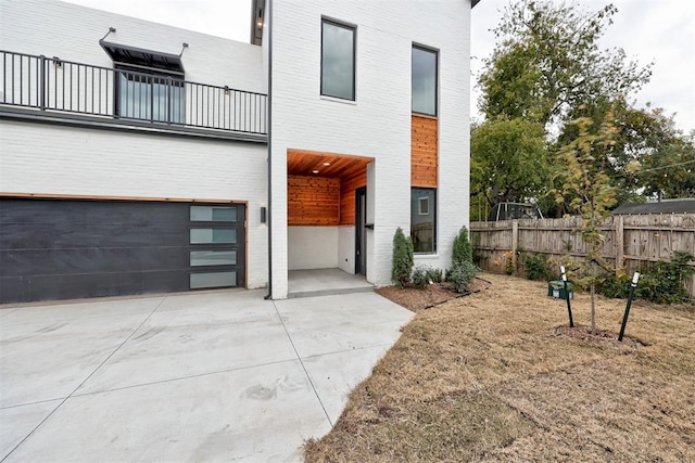 back of property featuring a balcony and a garage