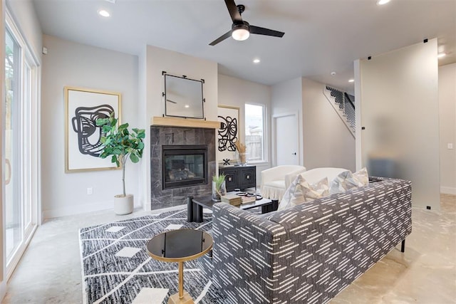 living room featuring a tile fireplace and ceiling fan