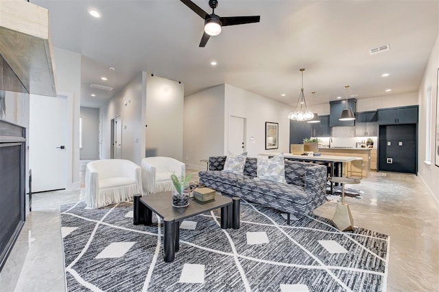 living room with sink and ceiling fan with notable chandelier