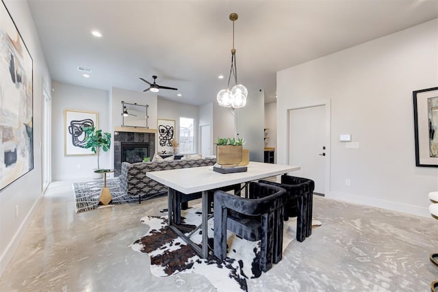 dining area with a fireplace and ceiling fan