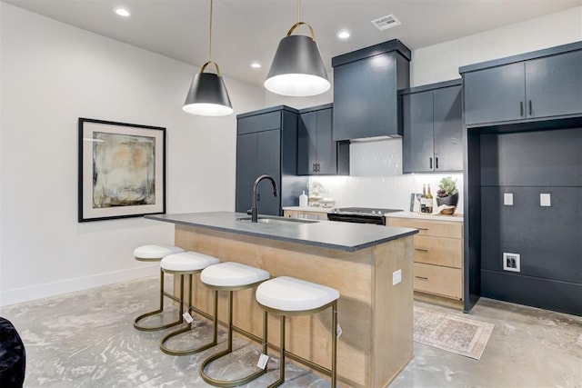 kitchen with pendant lighting, sink, premium range hood, a kitchen island with sink, and a kitchen bar