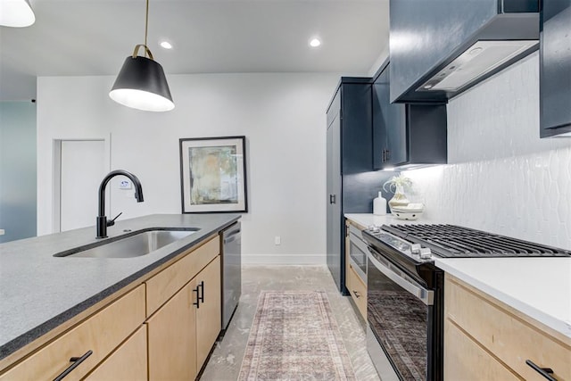 kitchen with appliances with stainless steel finishes, pendant lighting, sink, light brown cabinets, and wall chimney range hood