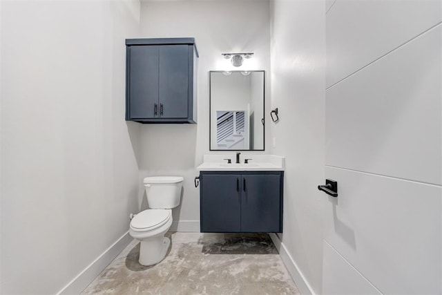 bathroom featuring vanity, concrete floors, and toilet