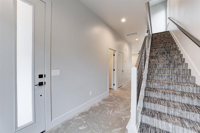 stairs with concrete flooring