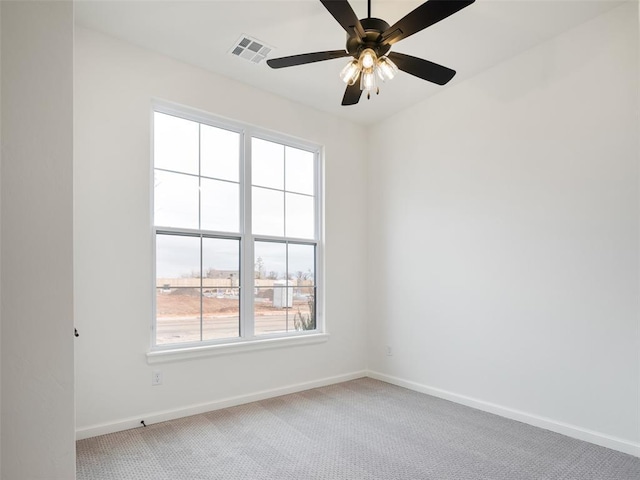 empty room featuring light colored carpet, visible vents, and baseboards