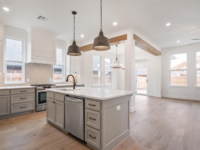 kitchen featuring visible vents, light wood-style flooring, appliances with stainless steel finishes, gray cabinetry, and a sink