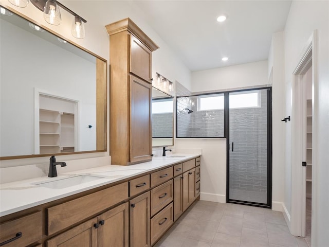 full bath featuring double vanity, a shower stall, a spacious closet, and a sink